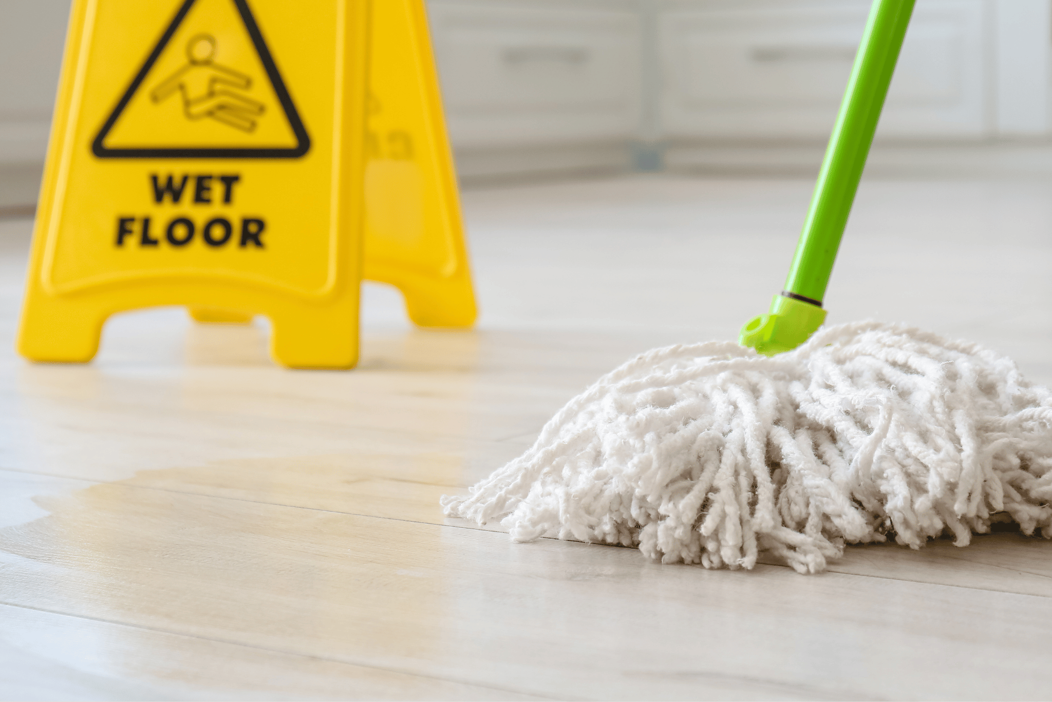 Mopping floors with a wet floor sign.