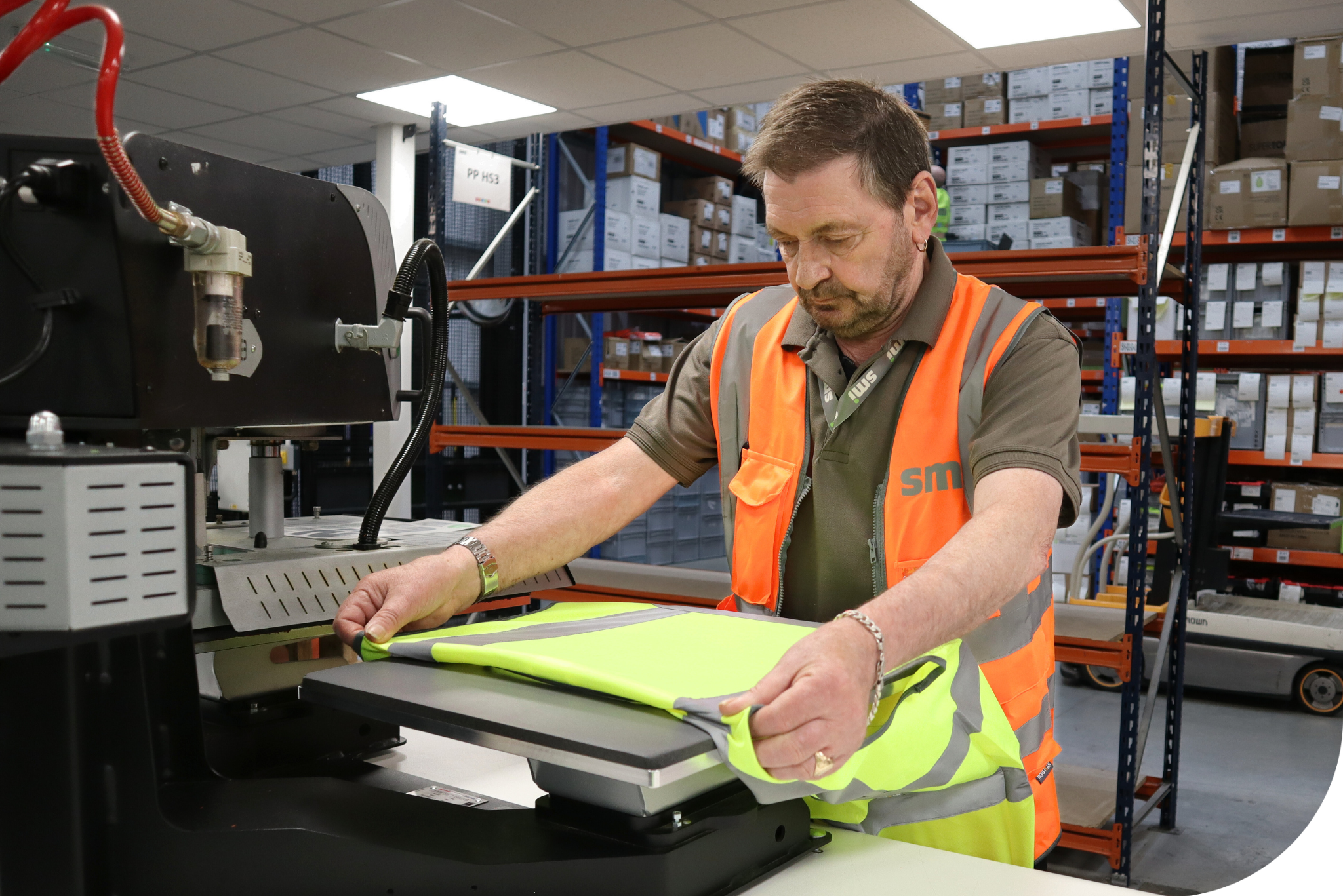 Man wearing hi-vis operating a heat seal machine.