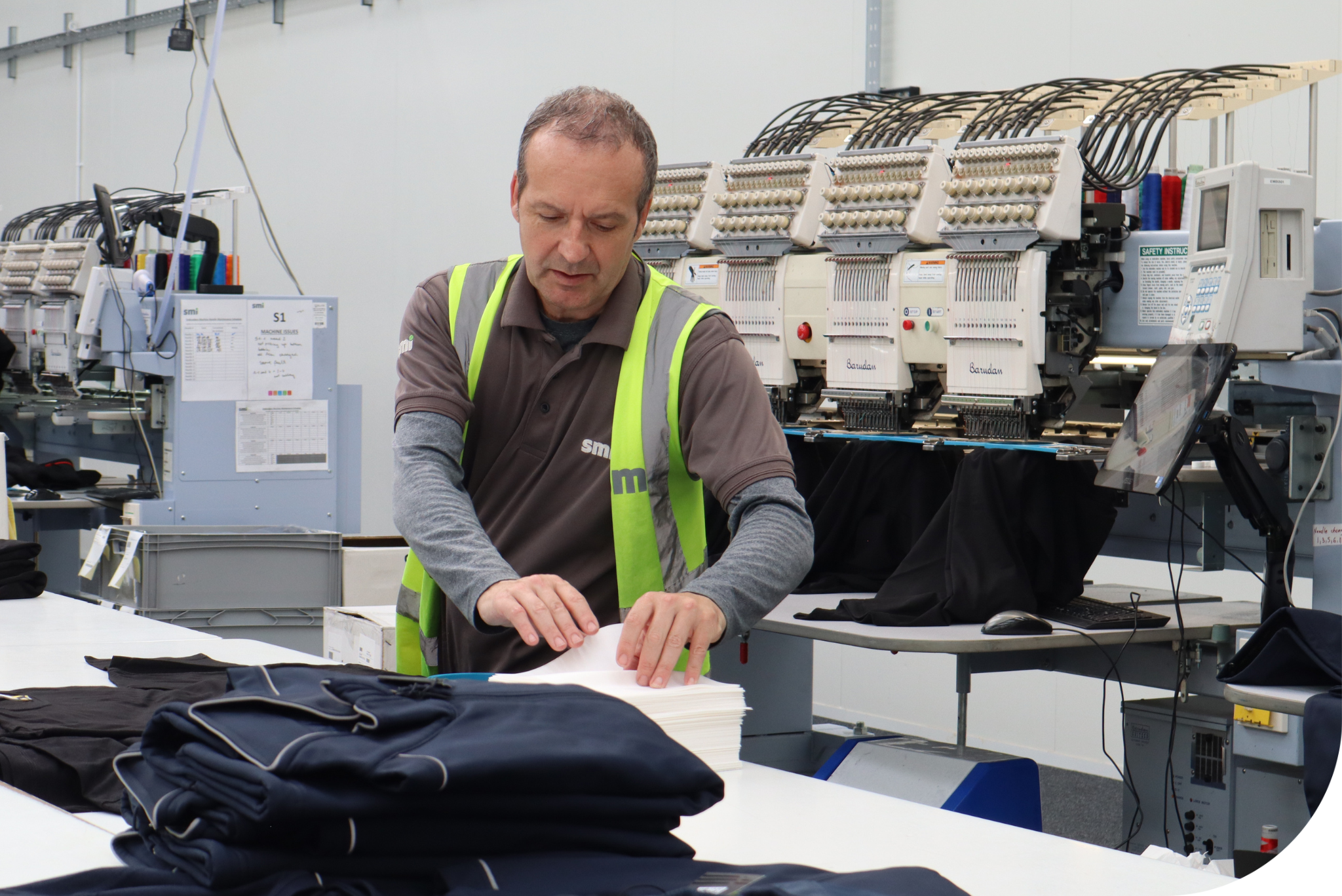 Man in hi-vis working in a workwear branding facility.